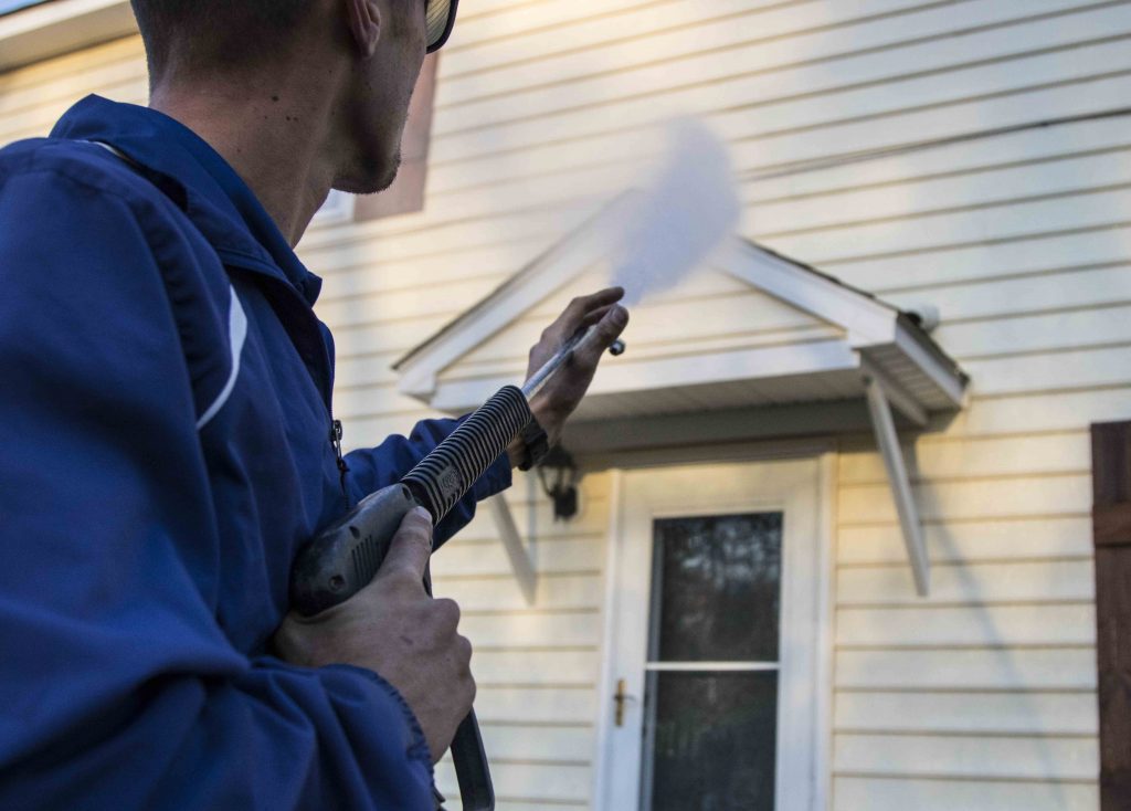 Power washing siding on a house