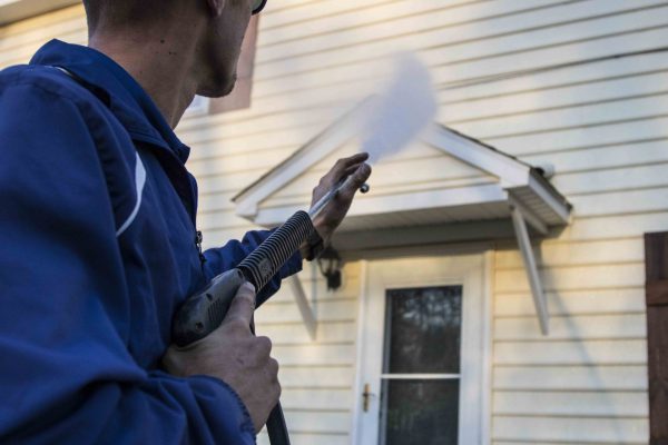 Power washing siding on a house