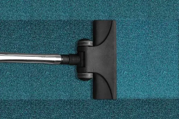 Vacuuming a clean blue carpet as part of professional carpet cleaning for residents in Baltimore, MD.